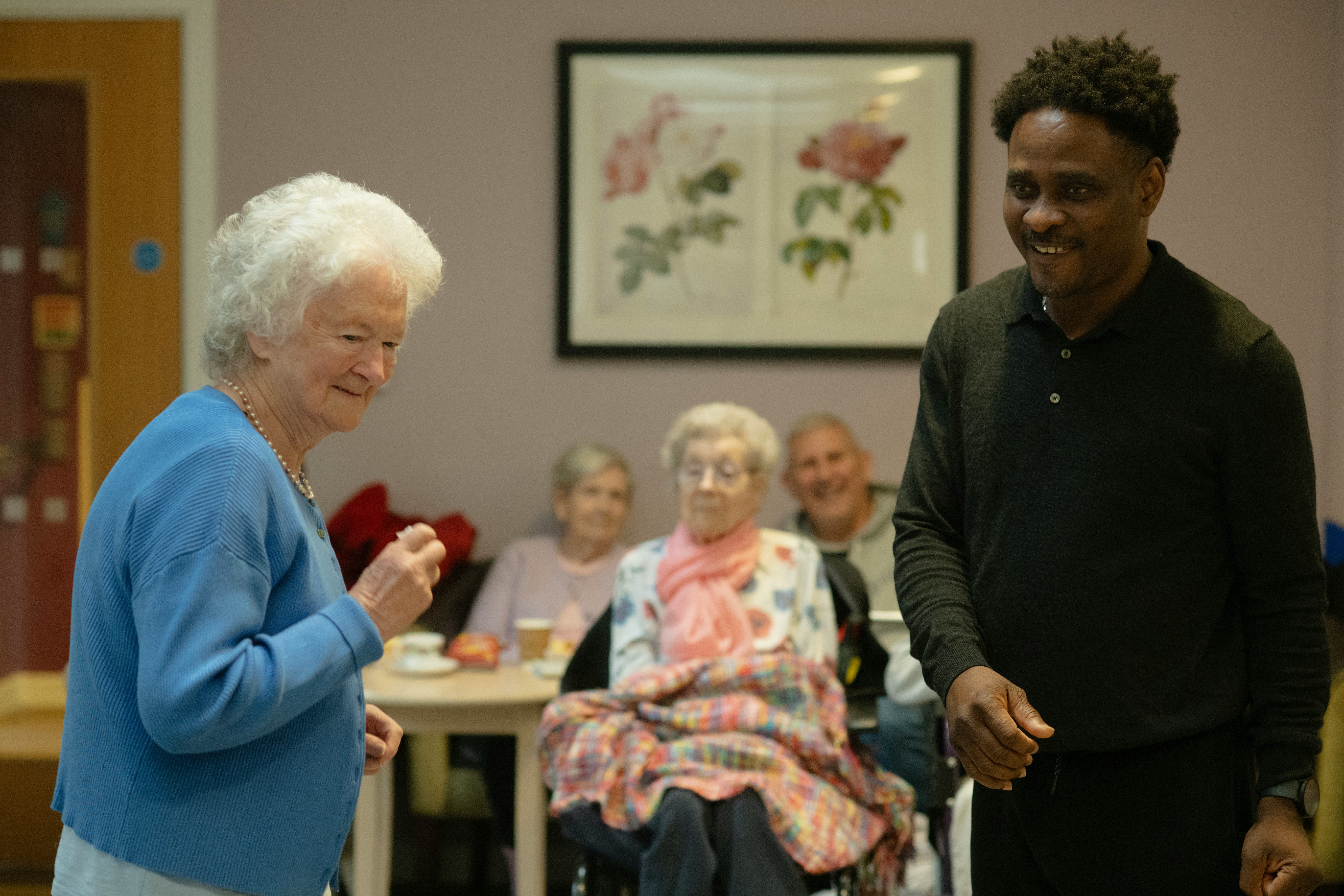 Elderly people and caregiver in a common room